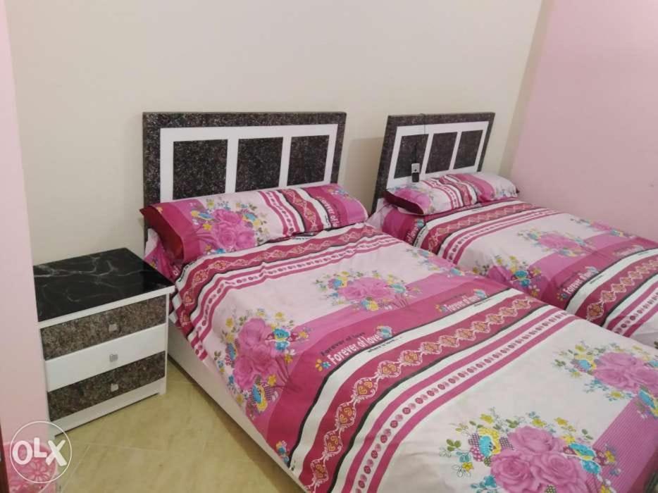 赫尔格达كمبوند سيبريا的卧室内的两张床,配有粉红色
