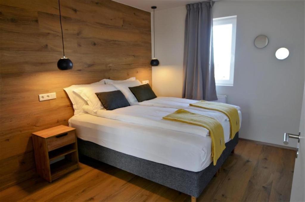 教堂城Stracta Apartments的一间卧室设有一张带木墙的大床