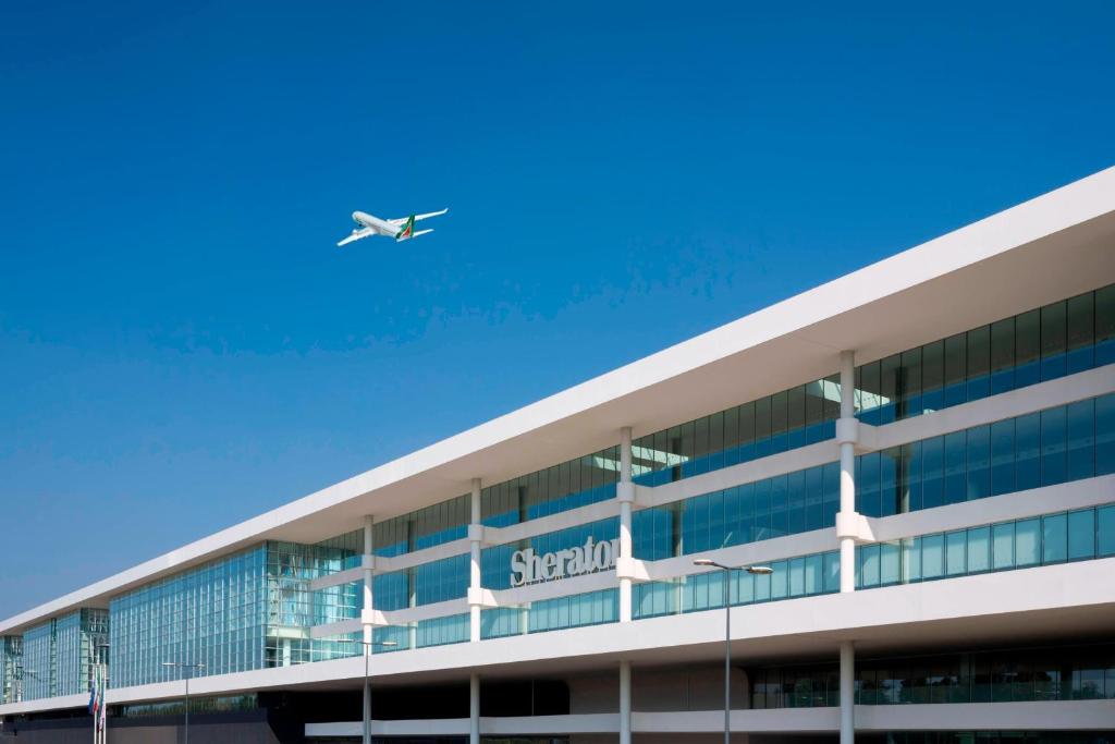 Ferno喜来登米兰马尔彭萨机场酒店及会议中心的飞机飞越有机场的大楼