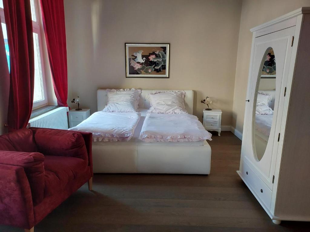 汉堡Villa Rosali Boutique Hotel的一间卧室配有一张床、一把椅子和镜子