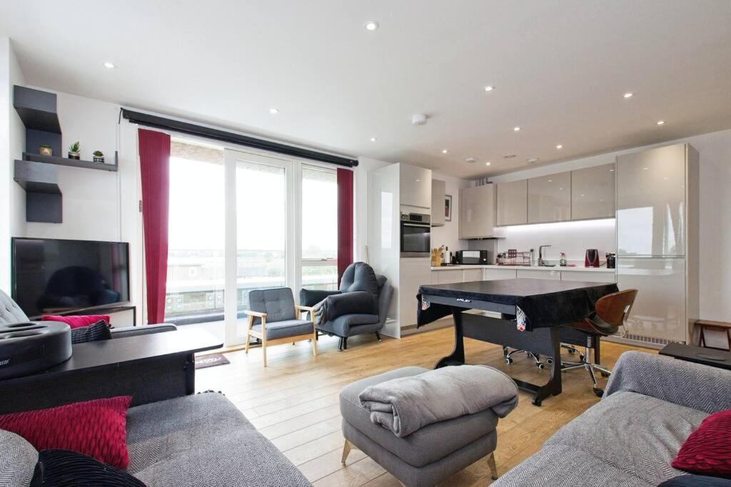 伦敦Greenwich O2 Apartment的一间带三角钢琴的客厅和一间厨房