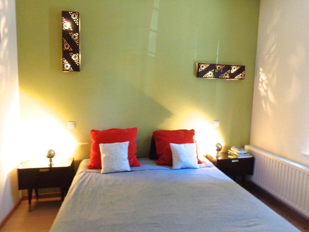 布鲁塞尔十二宫住宿加早餐旅馆的一间卧室配有红色和白色枕头的床