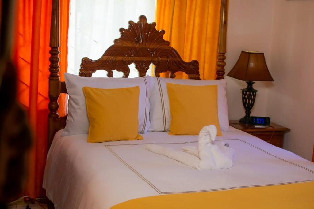 Buff BayWindbreak Villa的一张带木制床头板和黄色枕头的床