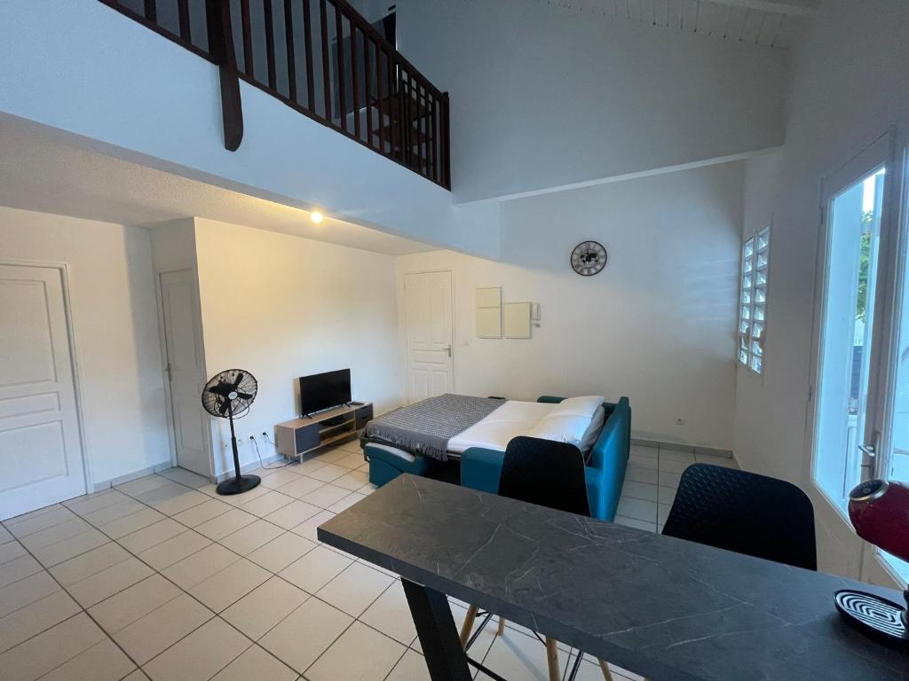 哥西尔Bel appartement cosy - Les pieds dans l'eau的客房设有1张床、1张桌子和1台电视。