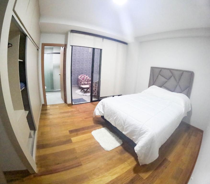 拉巴斯Apartamento Luz de Luna2的卧室配有白色的床,铺有木地板