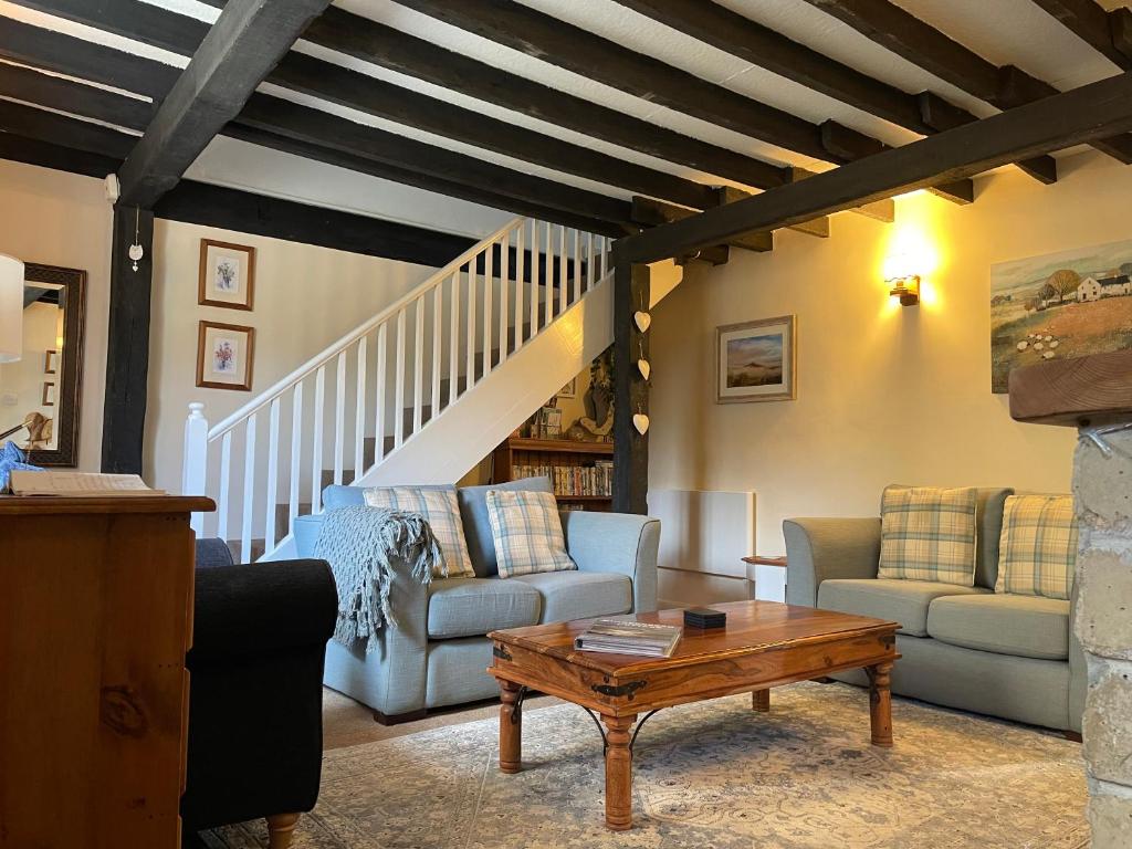 ChideockGingerbread Cottage的客厅配有两张沙发和一张桌子