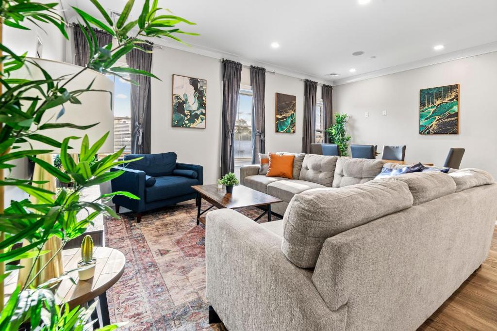 波士顿Spacious Fully Furnished Apartment by Logan Airport的带沙发、桌子和植物的客厅