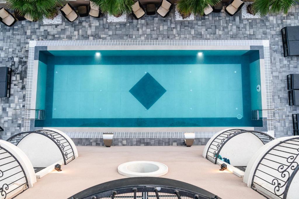 帕科坦Boutique Hotel Bora & Villas Garamm的一个带三把椅子和一张桌子的大型游泳池