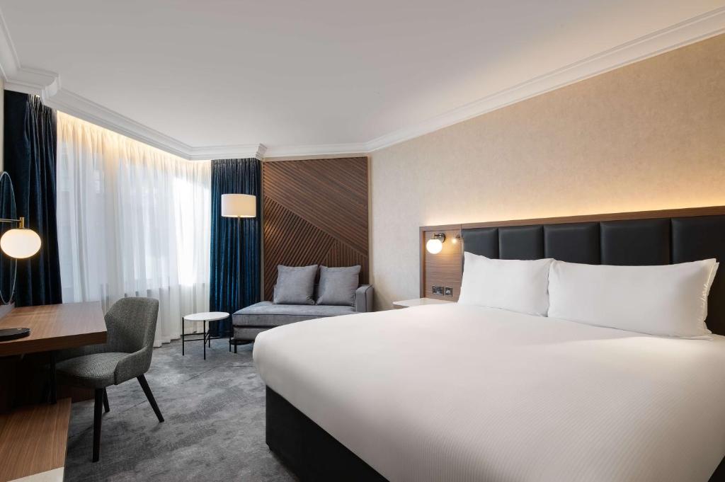 伦敦希尔顿伦敦大都会酒店的酒店客房设有一张大床和一张书桌。