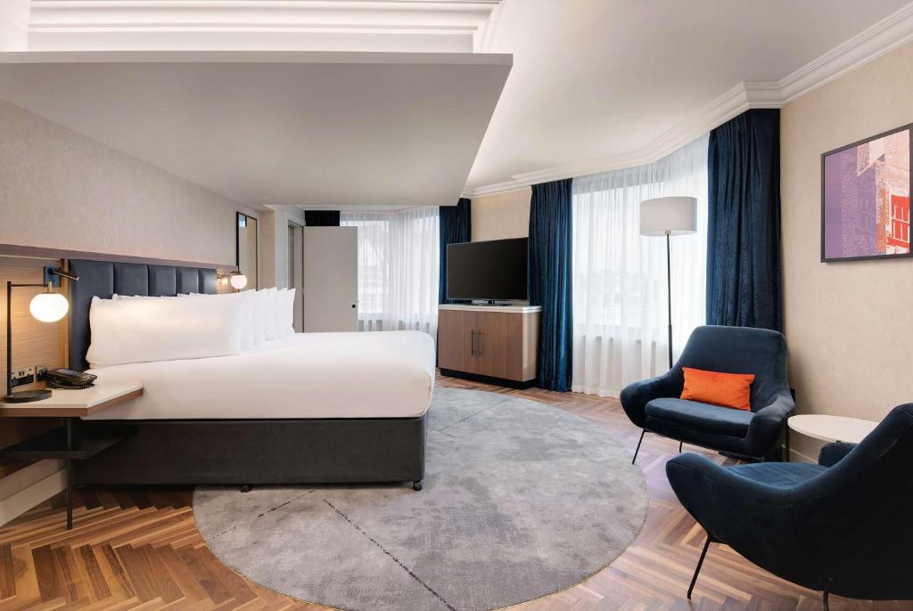 伦敦希尔顿伦敦大都会酒店的酒店客房配有一张床、一张桌子和一把椅子。