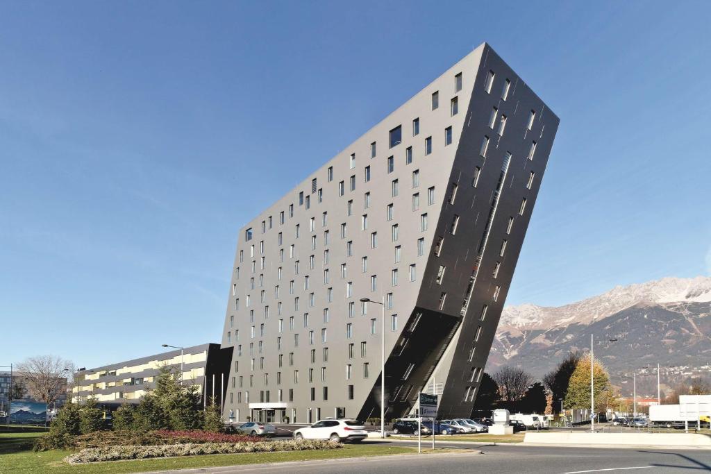 因斯布鲁克Tivoli Hotel Innsbruck的一座高大的白色建筑,有很多窗户