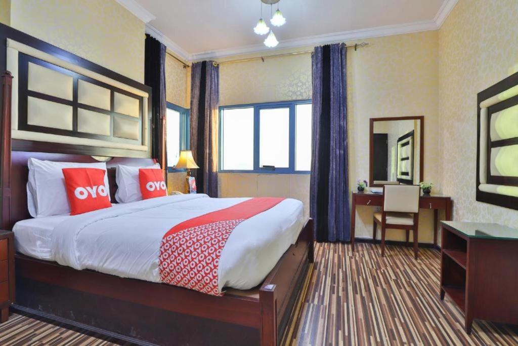 拉斯阿尔卡麦Grand PJ Hotel - Free Parking的酒店客房设有一张大床和一张书桌。