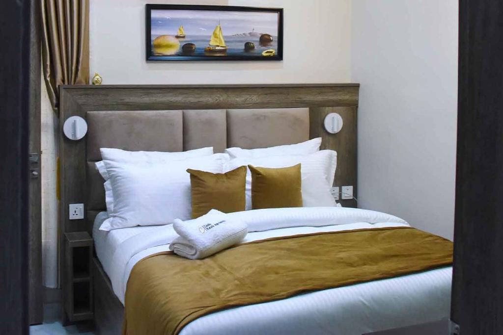 阿布贾Castle Estate Apartments的卧室配有带白色枕头的大床