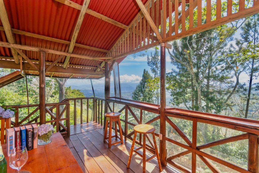 图里亚尔瓦Vista Turrialba Lodge的客房设有带桌椅的阳台。