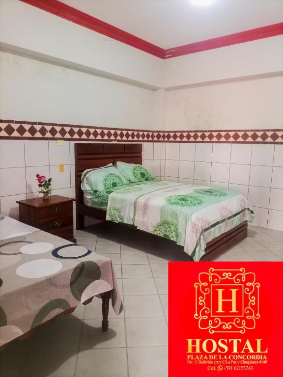 圣克鲁斯Hostal Plaza de la Concordia的酒店客房带两张床和红色标志