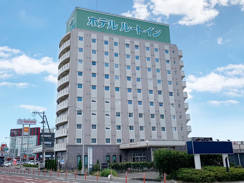 多贺城市Hotel Route-Inn Sendaiko Kita Inter的一座大建筑,上面有标志