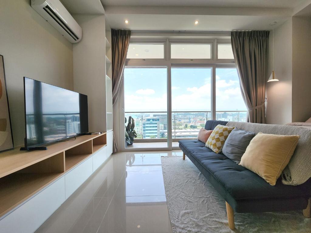 古晋Kuching Town DeSunset - Balcony with Amazing View的客厅设有蓝色的沙发和大窗户