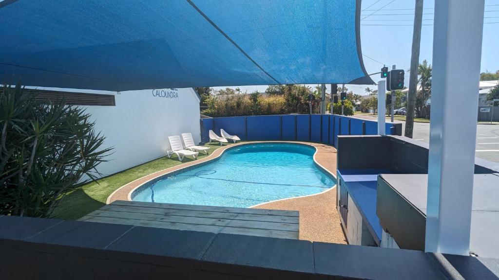卡伦德拉卡拉德拉莫法特海滩汽车旅馆的一个带椅子和蓝伞的游泳池
