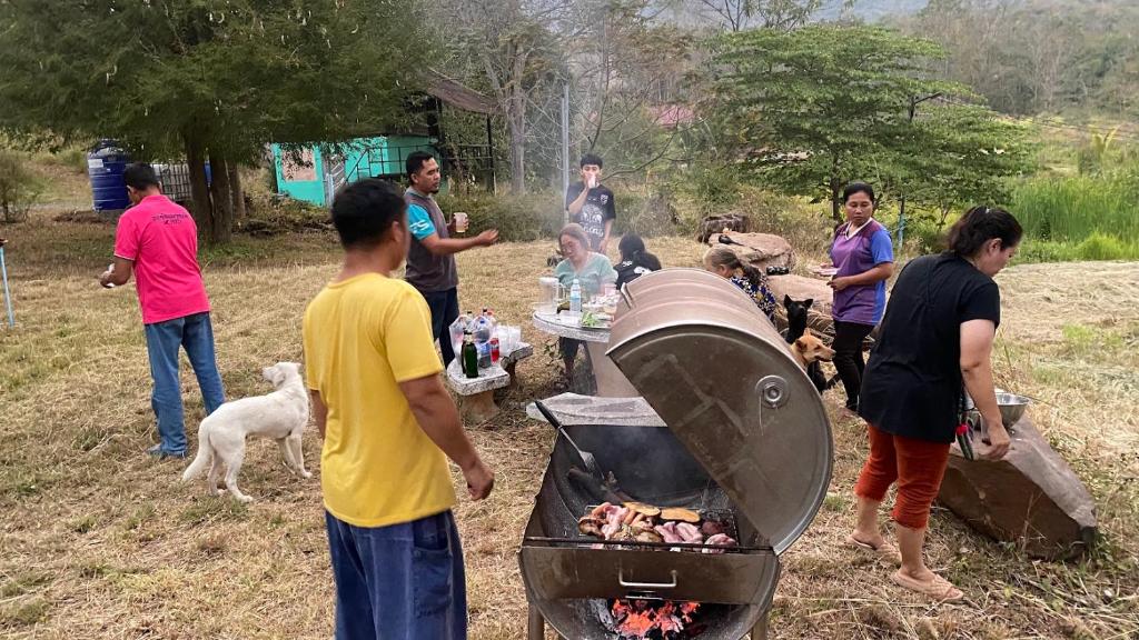 北冲Homtel Farmstay Campgrounds的一群人站在烧烤炉旁