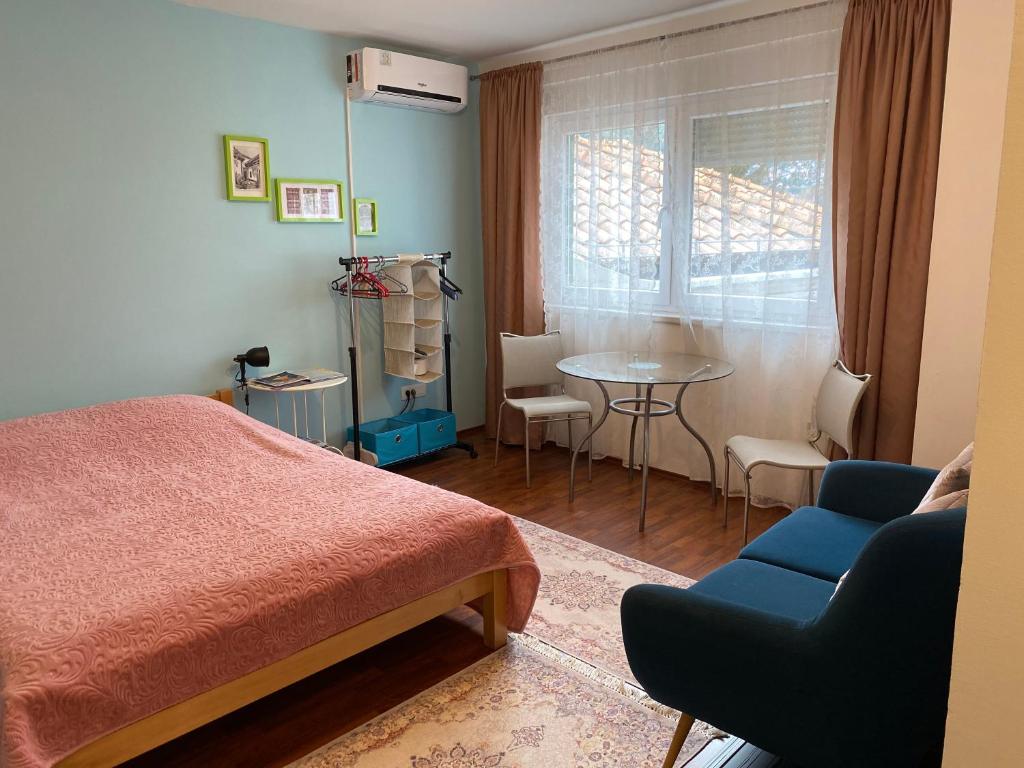 萨拉热窝Green Gate Apartments的卧室配有1张床、1张桌子和1把椅子