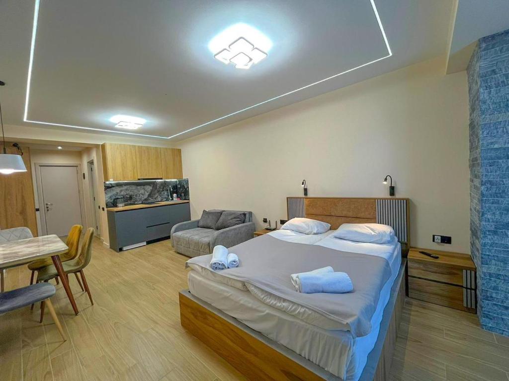 古多里New Gudauri F4的一间卧室配有一张大床和一张桌子及椅子