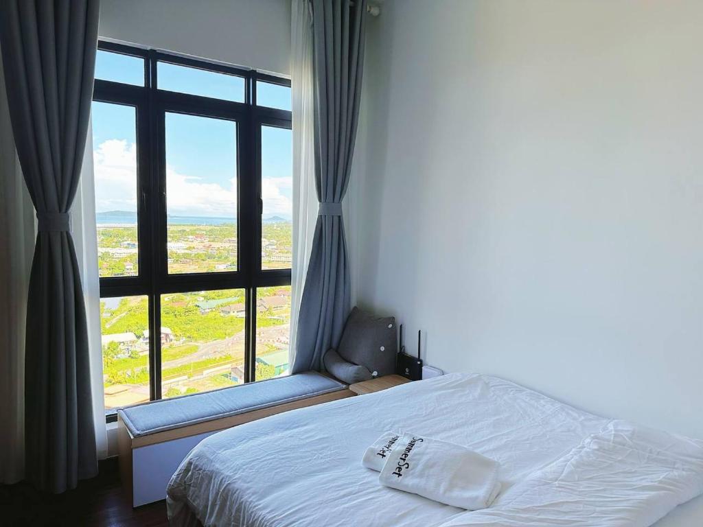 哥打京那巴鲁K Avenue Seaview Nearby Kota Kinabalu Airport的一间卧室设有一张床和一个大窗户
