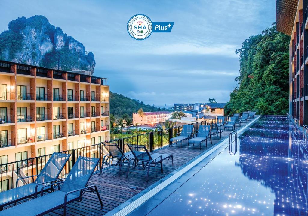 奥南海滩Sugar Marina Hotel CLIFFHANGER Aonang - SHA Extra Plus的酒店游泳池旁设有椅子