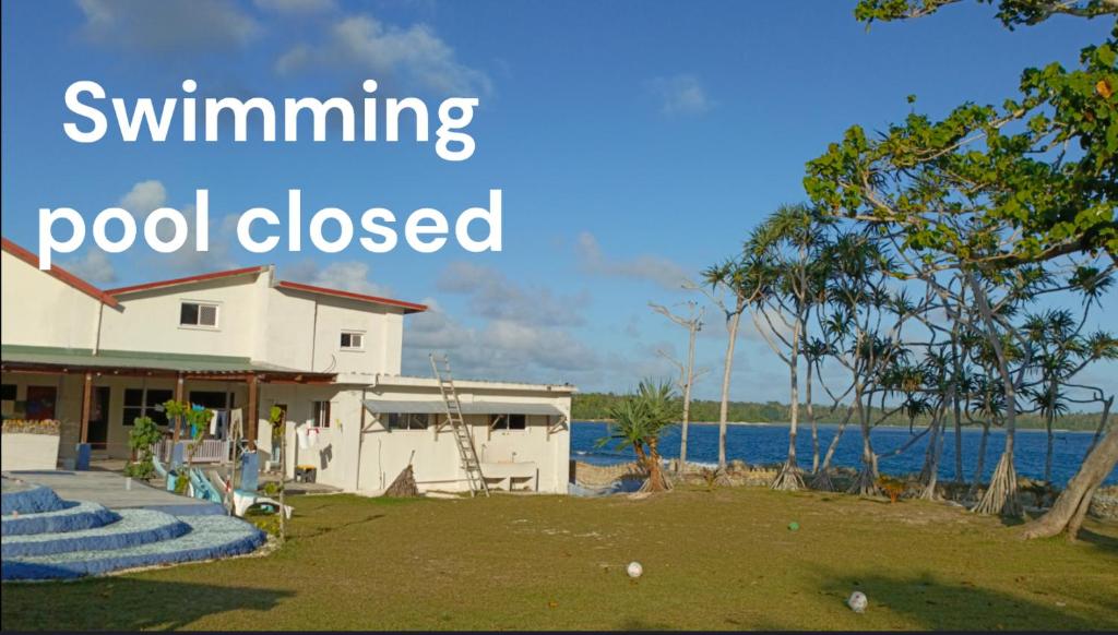 维拉港Bluepango Guest House的水边的房子,游泳池关闭