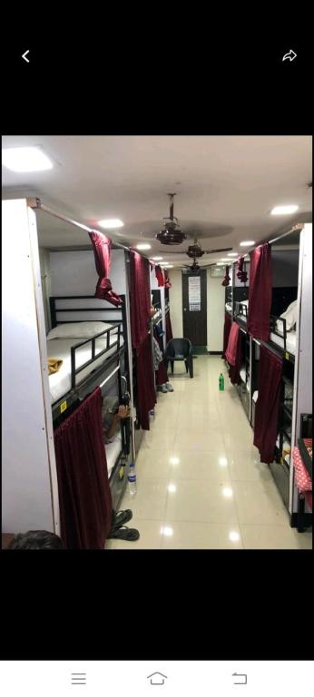 孟买Royal Orchid'S AC Dormitory的长长的走廊,房间内设有双层床