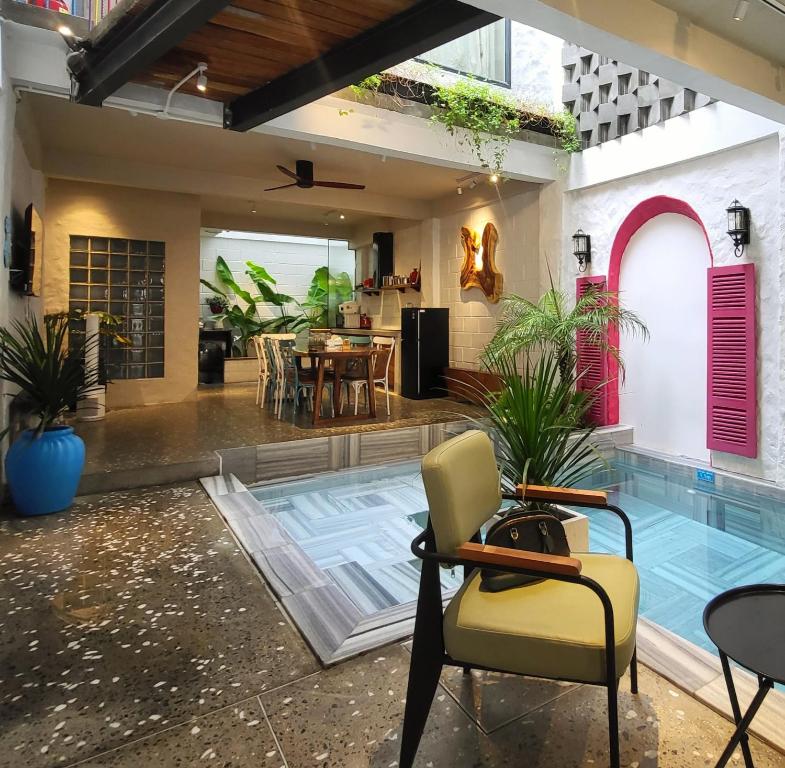 岘港Santori Villa My Khe Beach的房屋设有游泳池、椅子和桌子