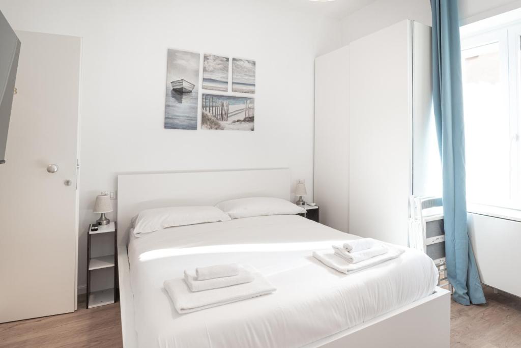罗马Residence San Paolo的白色卧室配有带2条毛巾的床