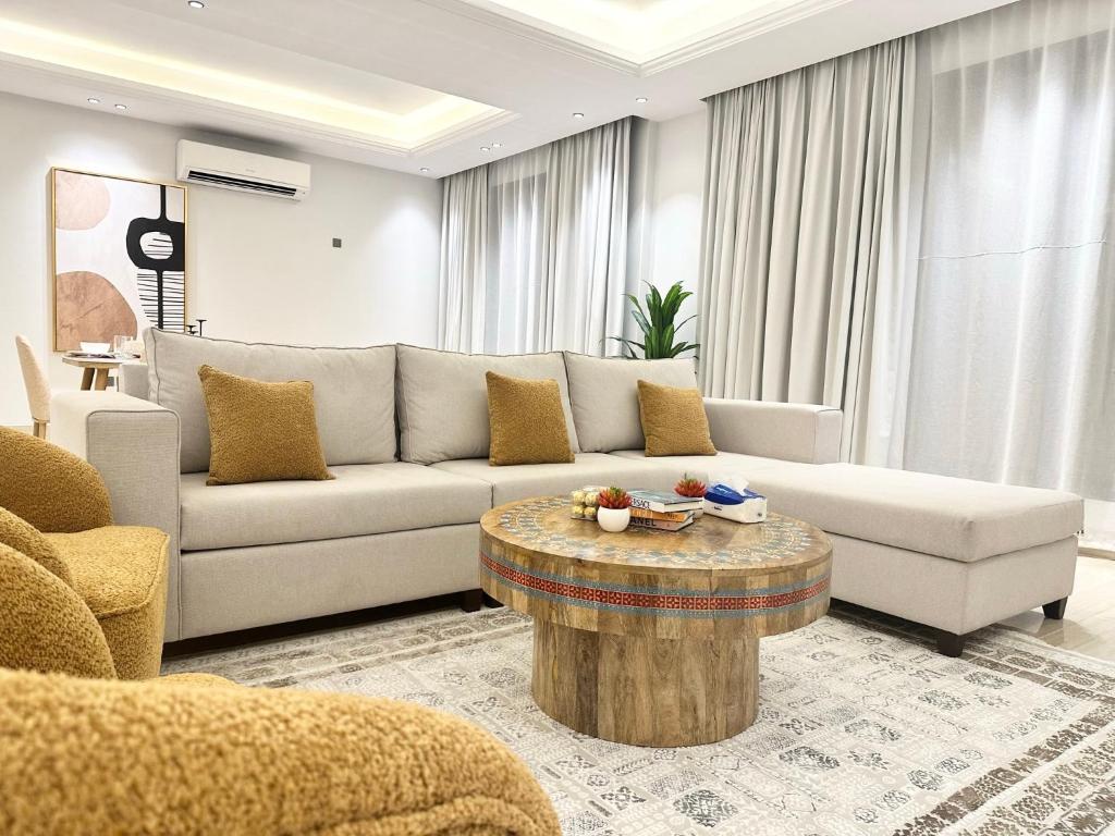 利雅德Luxurious 3 Bedroom Apartment - 5 minutes to Boulevard的带沙发和咖啡桌的客厅
