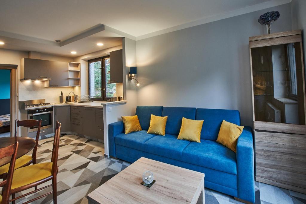 尼萨河畔亚布洛内茨Apartmán u Martina的一间带蓝色沙发的客厅和一间厨房