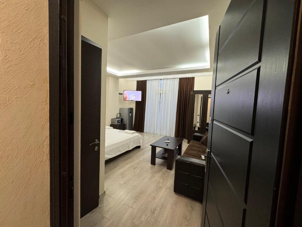 巴统Iko's Family Apartments的客房设有带一张床和一张桌子的卧室