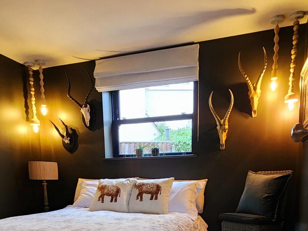 切尔滕纳姆La Casa Rossa - free parking的卧室配有一张床铺,墙上挂着鹿角