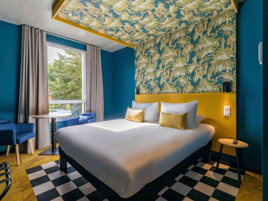 第戎ibis Styles Dijon Sud Domaine De Beauregard 21600 Longvic的一间卧室配有一张带蓝色墙壁的大床