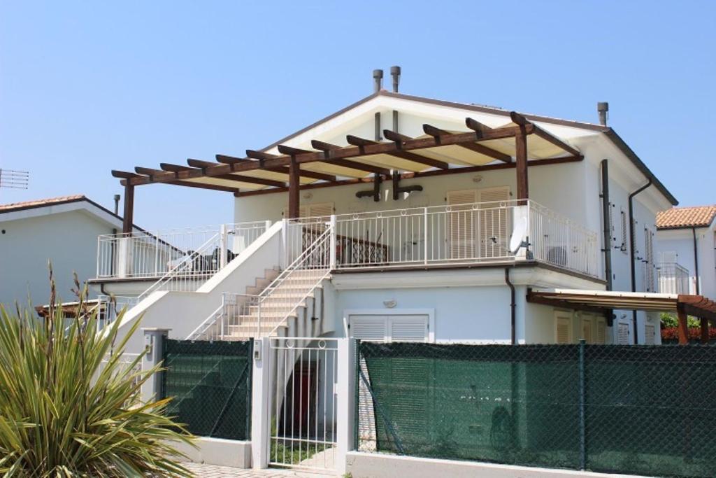 马瑟利Appartamenti Mac, trilocali vicino al mare con posto auto的带阳台和围栏的白色房屋