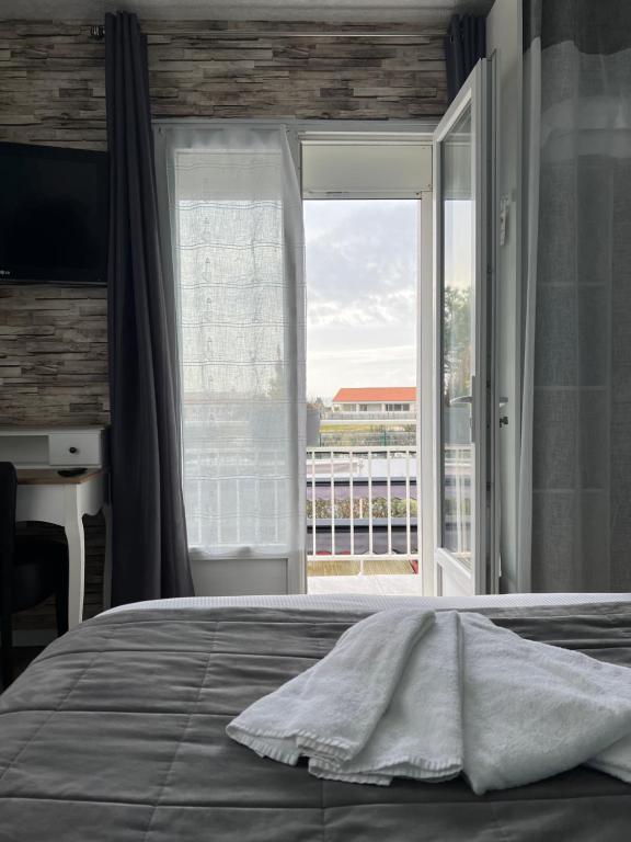 滨海拉特朗什金佩蒂特邦赫酒店的一间卧室设有一张床和一个大窗户