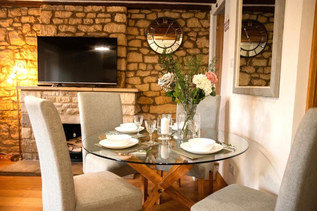 水上伯顿2 Bedroom Charming & Luxury Malt Cottage, Garden, Netflix, Free Parking的一间设有玻璃桌和椅子的用餐室
