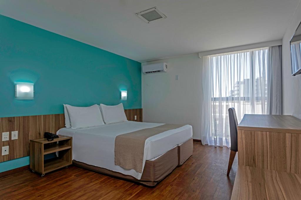 马塞约Marinas Maceió Hotel的一间卧室设有一张大床和蓝色的墙壁