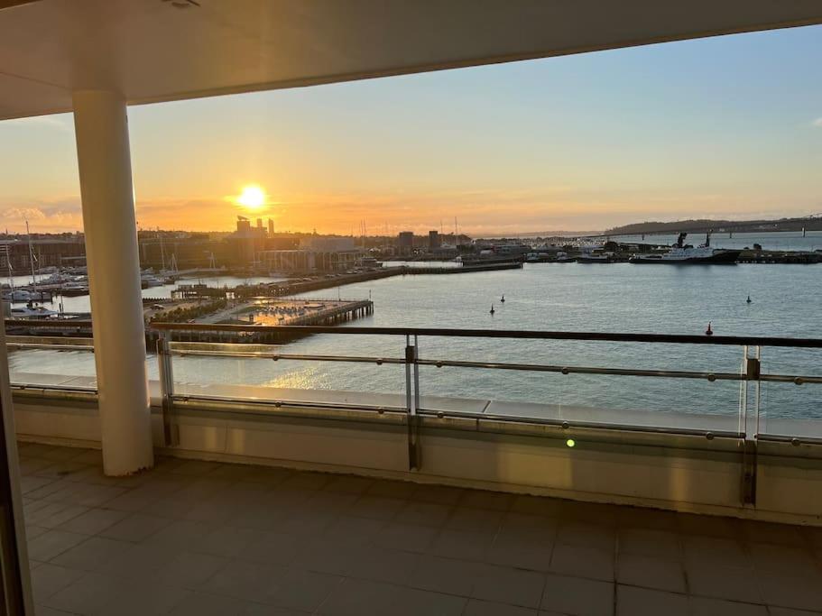 奥克兰Waterfront Seaview Hotel Apartment - same building block as Auckland Hilton的日落时从阳台上欣赏到水景