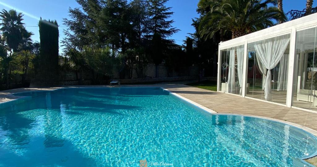 安德里亚B&B Villa Adriana的一座房子前面的蓝色海水游泳池