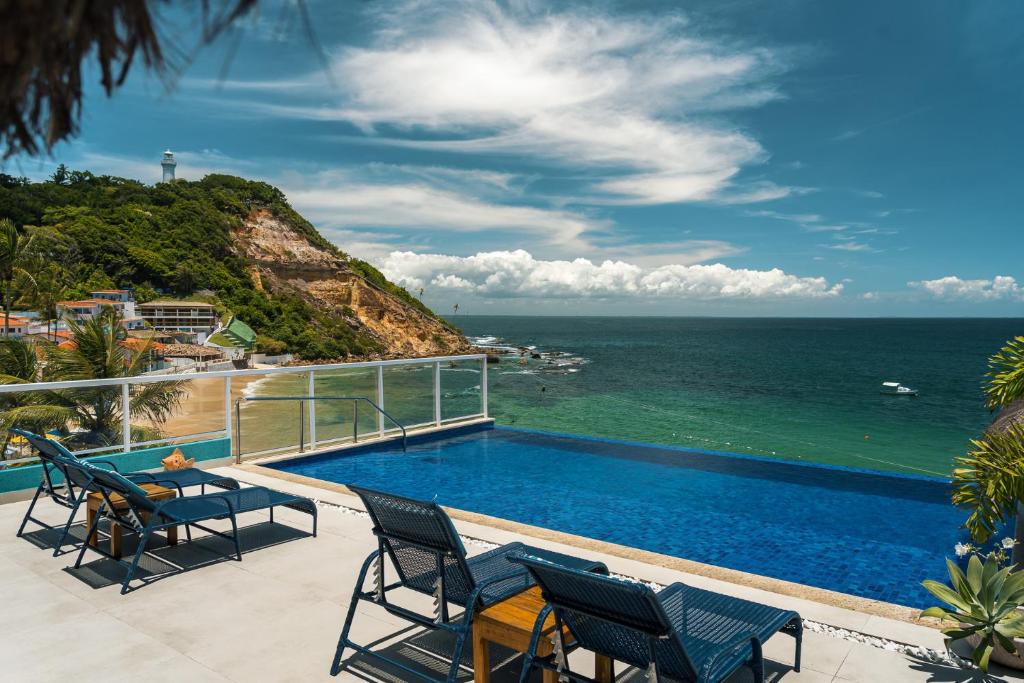 莫罗圣保罗Pousada Dona Moça的一个带游泳池和海洋的阳台