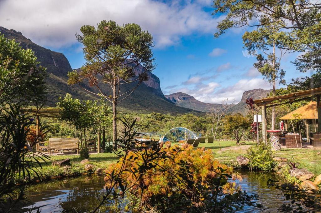 韦尔卡鲍Pousada do Capão Chapada Diamantina的一座花园,花园内有河流和山脉