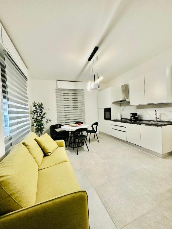 科莫Appartamento Dolce Vita - Parking & Self Check-in的一间带黄色沙发的客厅和一间厨房