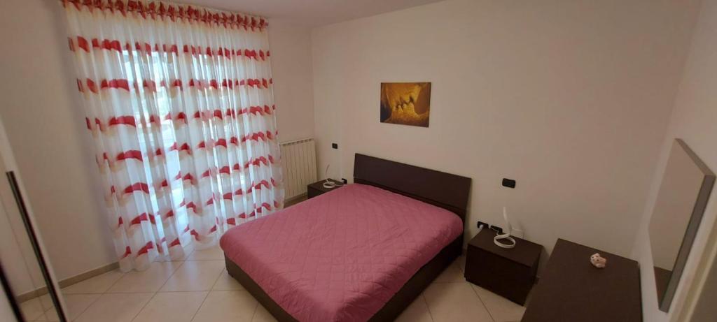 巴列塔Casa vacanze Margherita的一间小卧室,配有粉红色的床和窗户