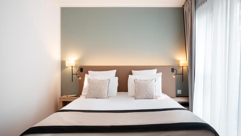 第戎Residhome Dijon Cité Des Vignes的一间卧室配有带白色床单和枕头的床。