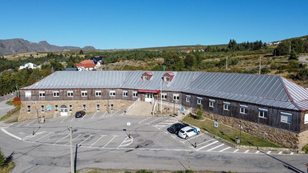 佩尼亚什达绍迪HI Serra da Estrela - Pousada de Juventude的享有带停车场的大型建筑的空中景致