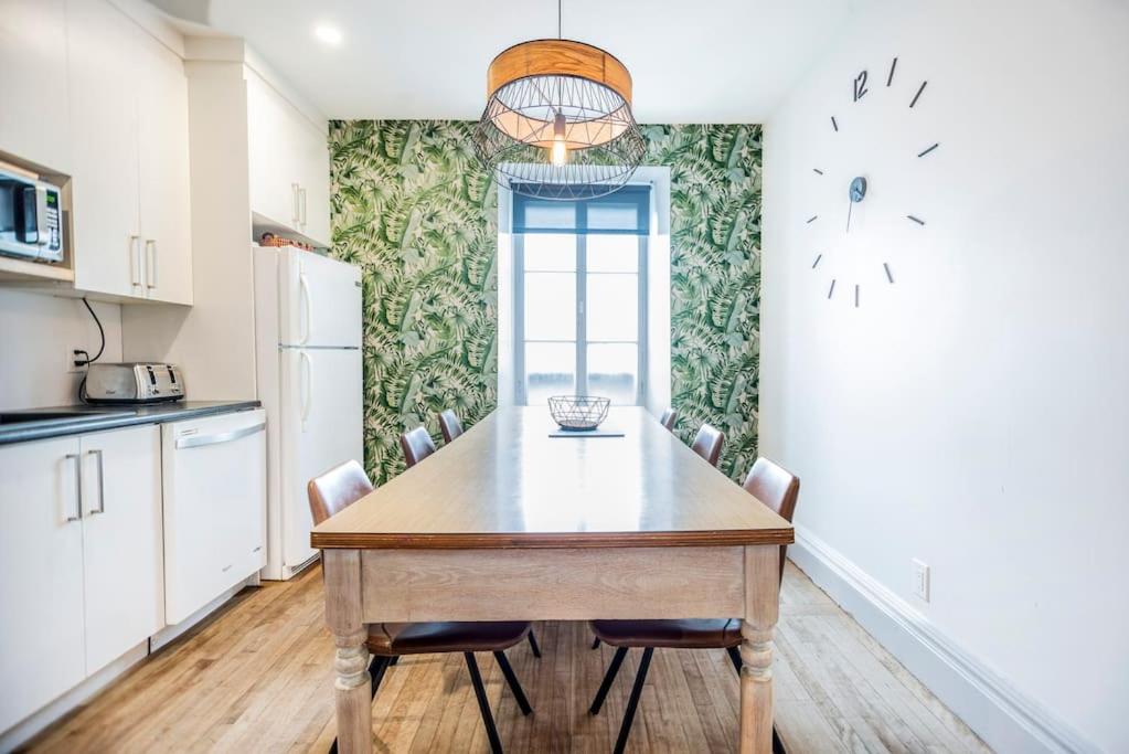 魁北克市La Maison Grenier La Résidence Beauport的厨房配有木桌和椅子