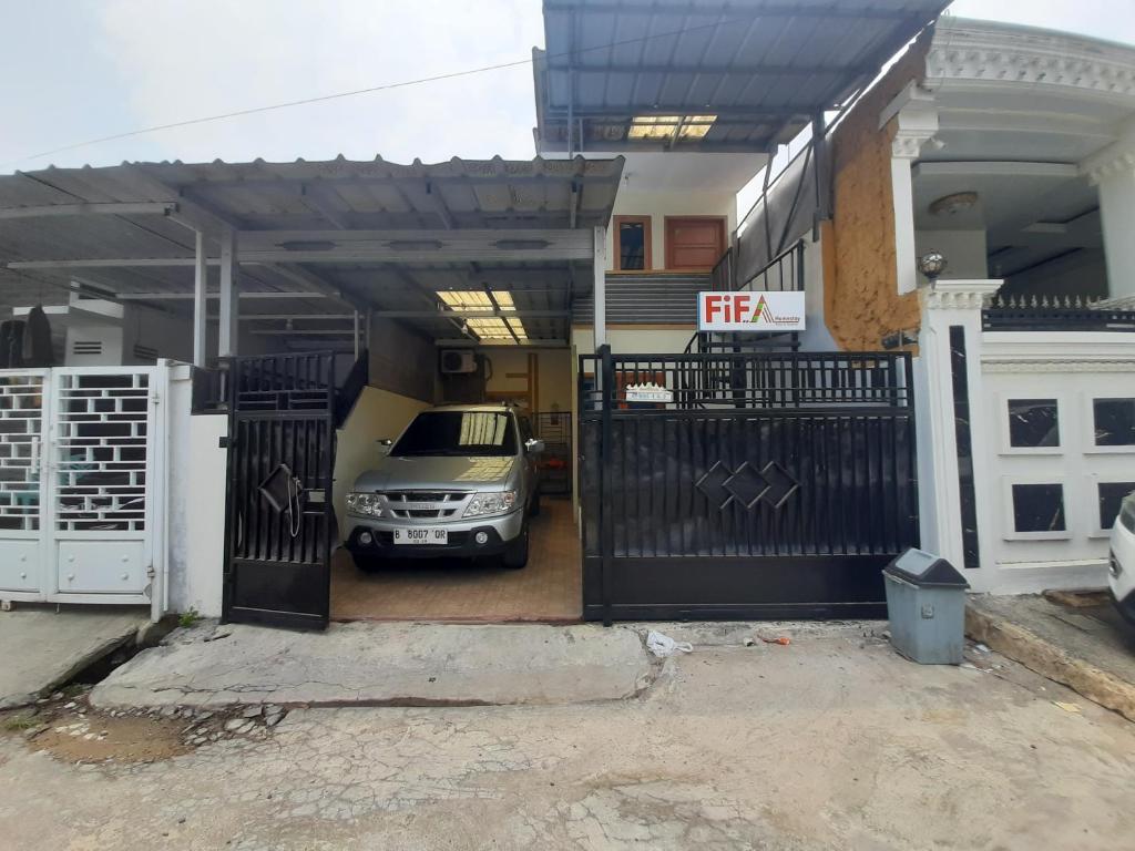 TanjungkarangFifa Homestay & Villa 2BR的停在房子旁边的车库里的汽车